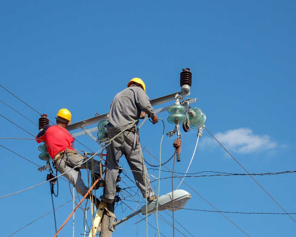 low-angle-shot-electric-linemen-working-pole